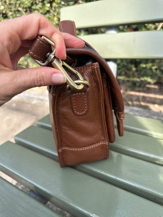 Die Satchel Bag ist in Seitenansicht gezeigt. Der Schulterriemen lässt sich an den D-Ringen einhacken.