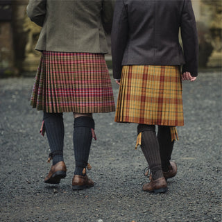 Zwei Personen von hinten in Kilts, rechts im Tartan Glen Affric, links im Tartan Royal Archers. Foto: House of Edgar.