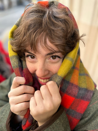 Die Stola ist eng um den Kopf unsers Models geschlungen. Sie ist mit einem klassischen Field Jacket in grünem Tweed kombiniert.