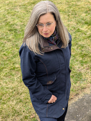 Der Regenmantel von schräg oben betrachtet. Das klassische Dunkelblau wird mit dem braunen Moleskin sportlich elegant kombiniert.