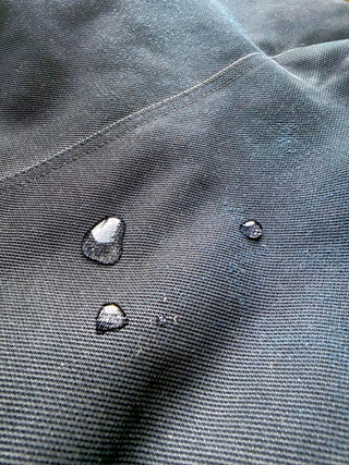 Am Regenmantel perlen die Wassertropfen richtig ab.